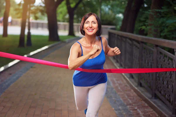 Vrouw kruist finishlijn — Stockfoto