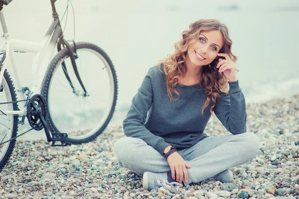 Mujer sentada con una bicicleta —  Fotos de Stock