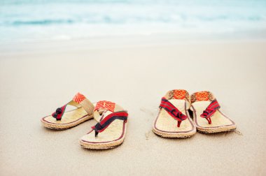 kumlu bir plaj üzerinde flip flop.