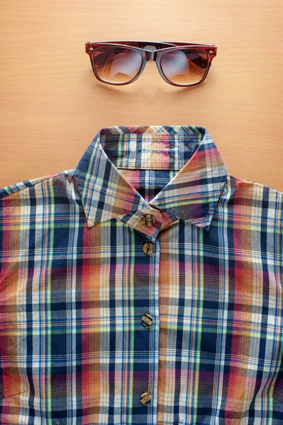 Shirt and sunglasses on wood — Stock Photo, Image