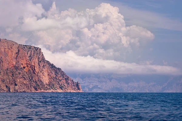 Rocha solitária com nuvens no mar — Fotografia de Stock