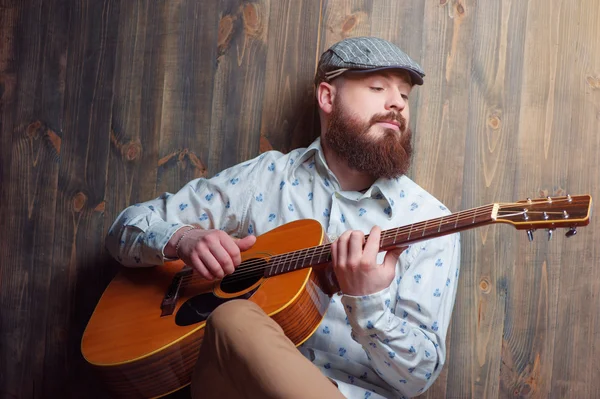 Hombre barbudo tocando la guitarra acústica — Foto de Stock