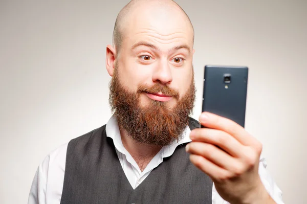Uomo barbuto stupito con smart phone — Foto Stock