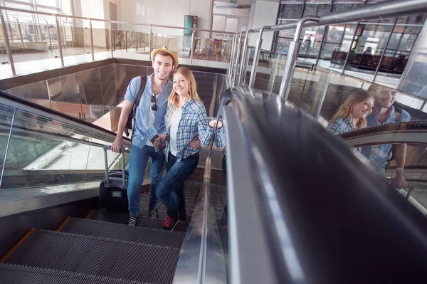 Pareja viajera en escalera mecánica de la terminal del aeropuerto . —  Fotos de Stock
