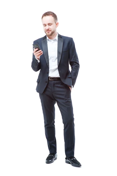 Hombre joven en traje usando teléfono inteligente . — Foto de Stock
