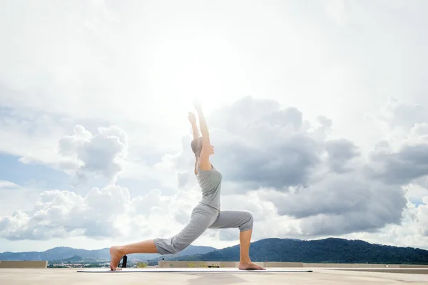 Young woman stretching on roof — Stock Photo, Image