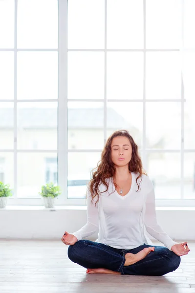 Jeune femme assise sur la position du lotus — Photo