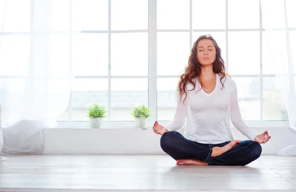 Young woman sitting on lotus position — Stock Photo, Image
