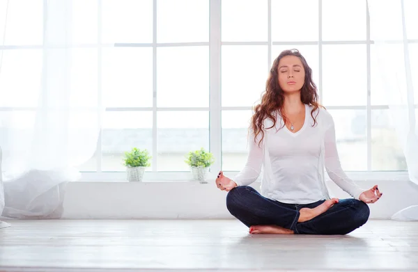 Jeune femme assise sur la position du lotus — Photo