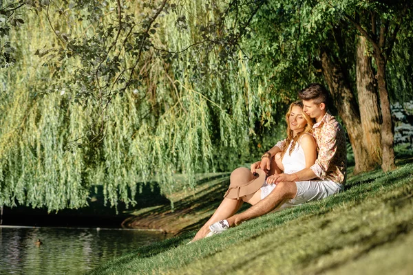 Sevgi dolu çift oturma yakın göl — Stok fotoğraf