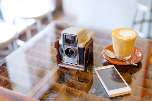 Kopp latte, smartphone och gammal kamera — Stockfoto