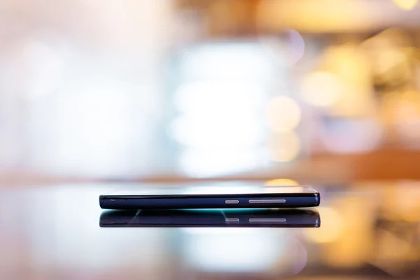 Smartphone σε γυάλινο τραπέζι. — Φωτογραφία Αρχείου