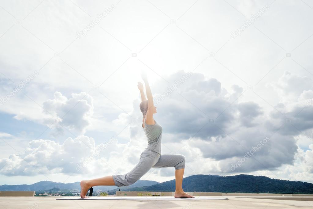 Young woman stretching on roof