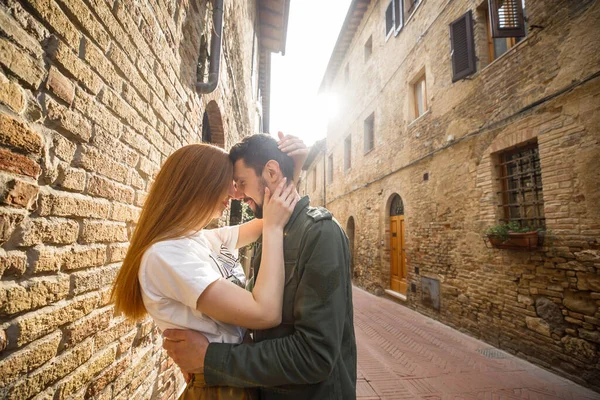 若い美しいカップル旅行者は日没時にイタリアの旧市街を歩く — ストック写真