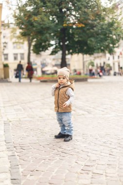 a little boy walking alone in the old town