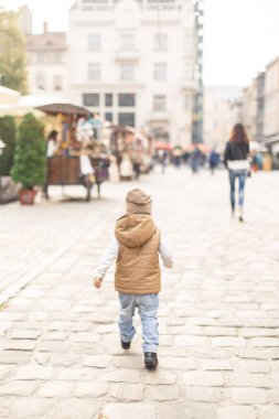 a little boy walking alone in the old town