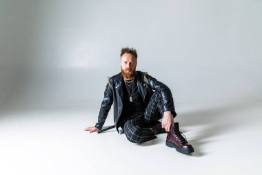 Beyaz arka planda siyah elbiseli vahşi bir adamın portresi.