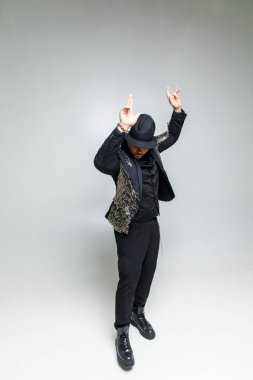 Beyaz arka planda siyah elbiseli vahşi bir adamın portresi.