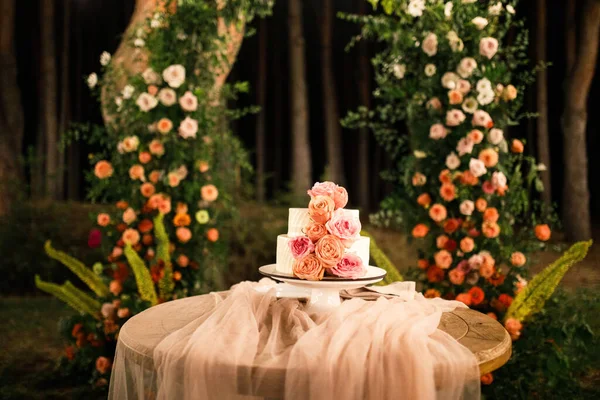 Pembe düğün pastası pembe bir masada duruyor.