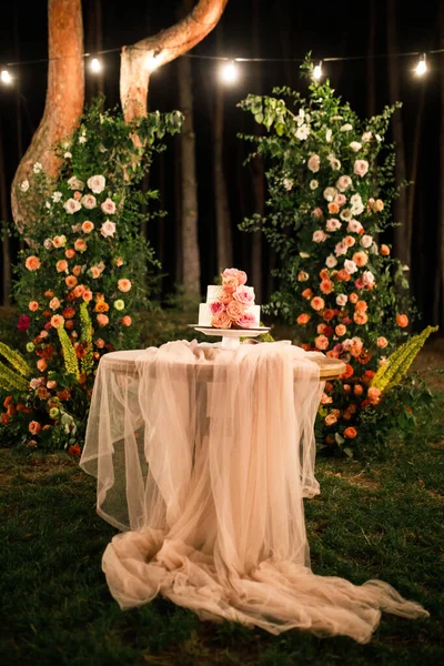 Pembe düğün pastası pembe bir masada duruyor.