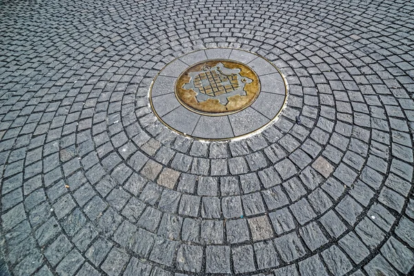 Fundo com paralelepípedos tendo no meio o símbolo de Timisoara — Fotografia de Stock