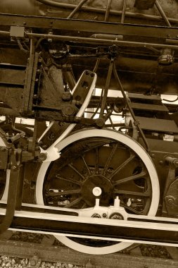 Sepia detail and close up of huge wheels at one old steam locomotive 13 clipart