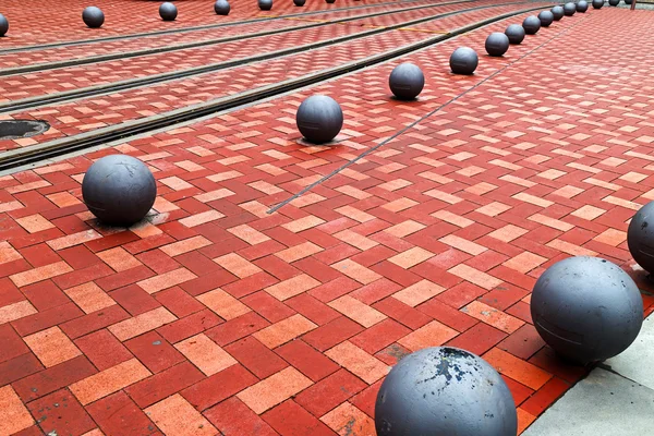 Detail des Kopfsteinpflaster-Bürgersteigs mit Straßenbahn und Zierkugeln — Stockfoto