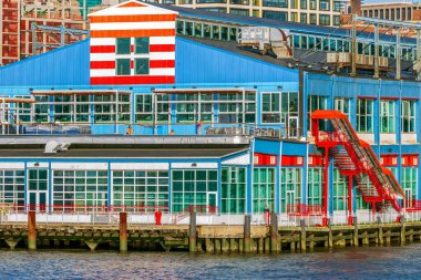 NEW YORK, ABD - 9 Mart 2020: Öğleden sonra ışıklarıyla Hudson Nehri 'nden Manhattan' daki renkli iskelenin görüntüsü.