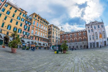 GENOA, ITALY - 20 Mart 2021: Piazza Caricamento 'daki renkli binalar, 1839 yılında Ceneviz' in Maddalena ilçesinde inşa edilen yaklaşık 9.000 mpp. Arka planda Aziz George Sarayı.
