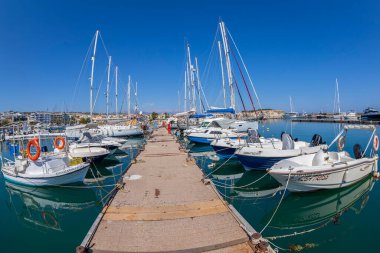 RETHYMNO, CRETE, GREECE - 20 HAZİRAN 2021: Yatları ve gemileri olan Rethymnon Marina. Burada da güzel bir Marina gezinti güvertesi var..