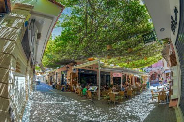 RETHYMNO, CRETE Adaları, GREECE - 20 Haziran 2021: Şehrin tarihi merkezinde yer alan turistlerle küçük ve resimli sokak terasları.