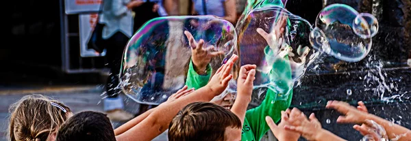 Los niños tratan de atrapar burbujas de jabón — Foto de Stock