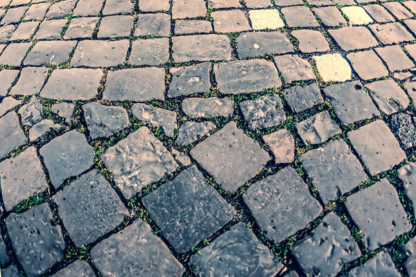 Vintage look at cobblestone sidewalk made of old cubic stones.