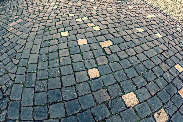 Vintage look at cobblestone sidewalk made of old cubic stones.