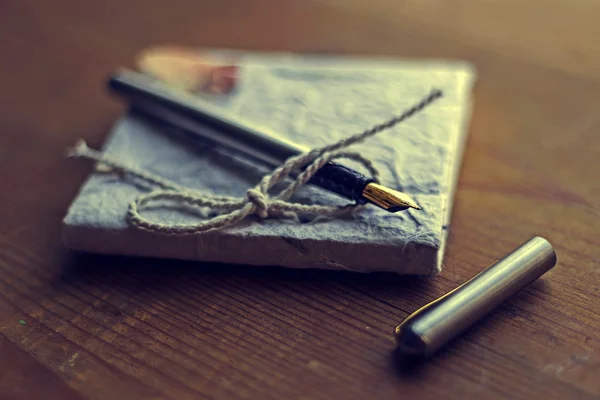 Старые воспоминания из дневника с ручкой на деревянном столе — стоковое фото