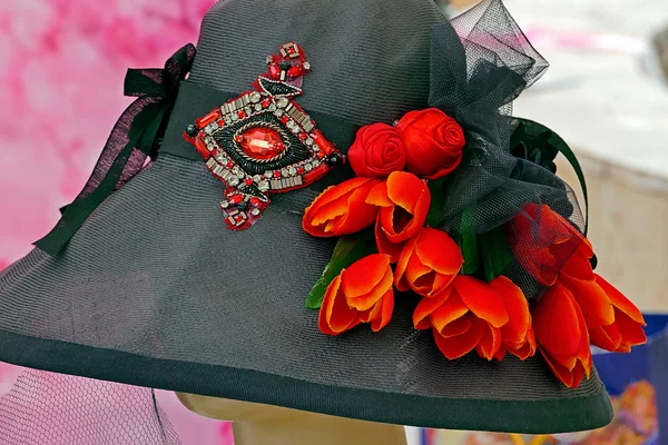 Zwarte hoed versierd met bloemen en sieraden — Stockfoto