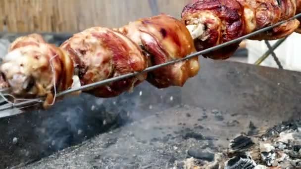 Fileiras de juntas de porco cozinhando em uma rotisserie — Vídeo de Stock