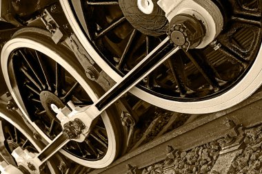 Sepia detail and close up of huge wheels at one old steam locomo clipart