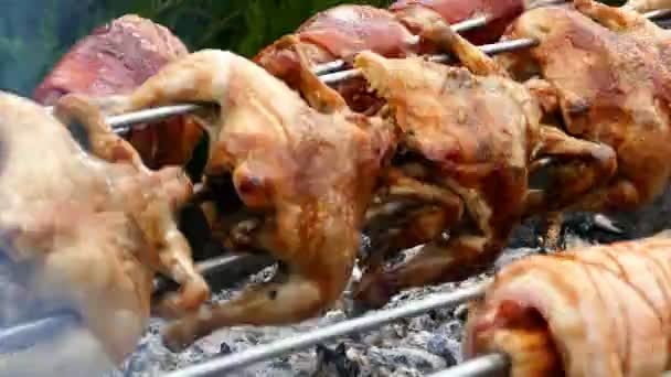 Filas de galinhas e juntas de porco, cozinhando em uma rotisserie. 4K — Vídeo de Stock