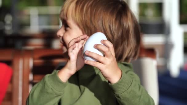 Den lille gutten pakker ut egg med overraskelse – stockvideo