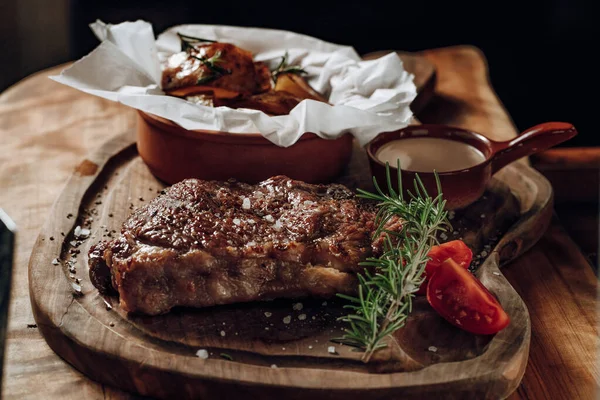 Ahşap bir yüzeyde fırında patates soslu lezzetli biftek.