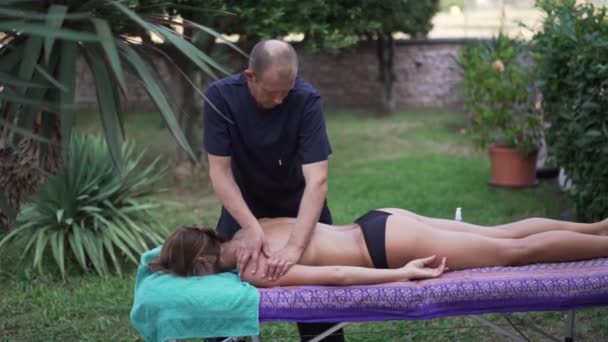 Massagens massagistas uma menina com um corpo bonito — Vídeo de Stock