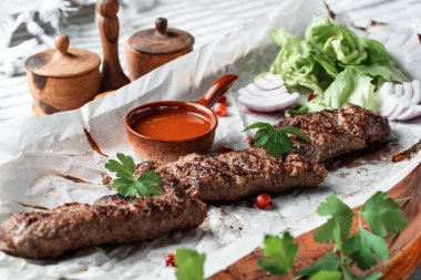 Soslu kebap ve tabakta yeşillik