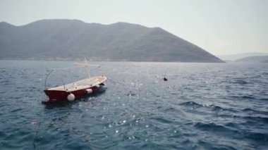 Karadağ Dağı 'nın arka planında dalgaların üzerinde tekne