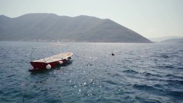 Boot op de golven tegen de achtergrond van de berg Montenegro — Stockvideo