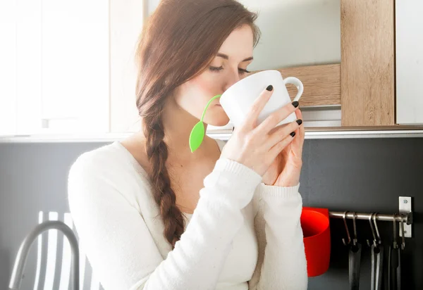 Woman with cup of tea in kitchen — Stock Photo, Image