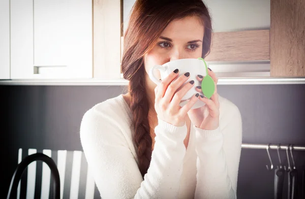 Mujer con taza de té en la cocina — Foto de Stock