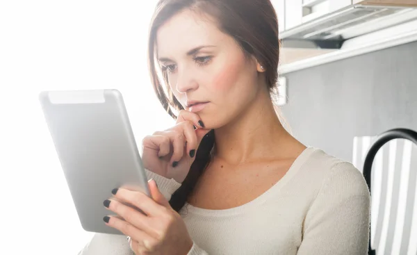 Femme utilisant une tablette pour cuisiner dans la cuisine de la maison — Photo