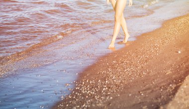 Yaz güneşi, kumlu plajda yürüyüş kadının tatil