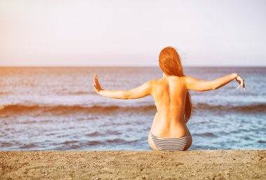 Kadın sıcak güneşin tadını yaz tatili sırasında sahilde